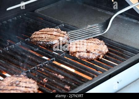 Hamburger di manzo alla griglia grigliati con barbecue all'aperto Foto Stock