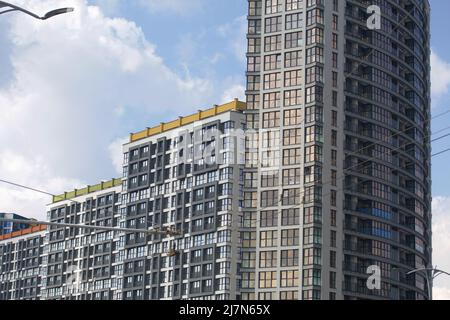 Costruzione di edifici a più piani. Moderno edificio a più piani. Case costruite in cemento e vetro. Foto Stock