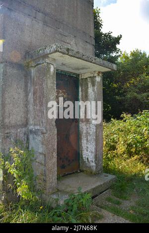 Parte inferiore di un'antica torre di guardia di confine con una porta d'ingresso arrugginita su un'ex fortificazione di confine della GDR, all'angolo di tre paesi di Assia, Thuring Foto Stock