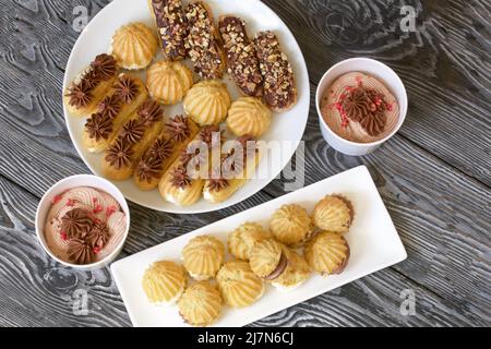 Eclairs fatti in casa con crema. Si trovano su un piatto. Pasticceria con crema. Primo piano. Foto Stock