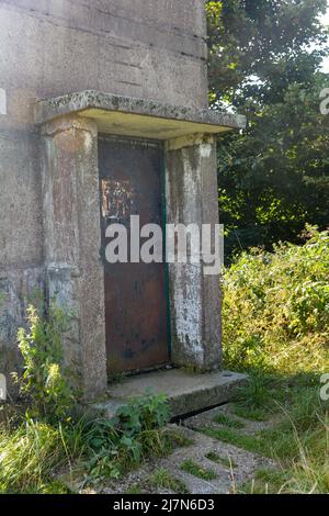 Parte inferiore di un'antica torre di guardia di confine con una porta d'ingresso arrugginita su un'ex fortificazione di confine della GDR, all'angolo di tre paesi di Assia, Thuring Foto Stock