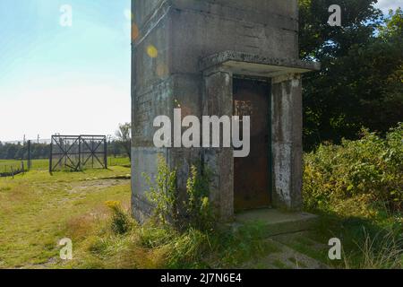 Parte inferiore di un'antica torre di guardia di confine con una porta d'ingresso arrugginita su un'ex fortificazione di confine della GDR, all'angolo di tre paesi di Assia, Thuring Foto Stock