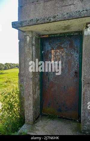 Parte inferiore di un'antica torre di guardia di confine con una porta d'ingresso arrugginita su un'ex fortificazione di confine della GDR, all'angolo di tre paesi di Assia, Thuring Foto Stock