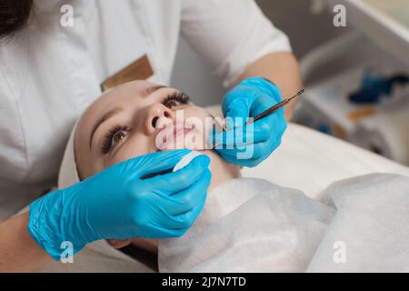 Una procedura per la pulizia meccanica o manuale del viso da parte di un estetista. Peeling cutaneo professionale. Igiene per la pelle Foto Stock