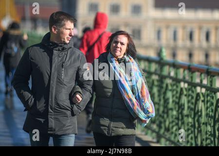 Donne ungheresi che camminano attraverso il Ponte della libertà durante l'inverno. Budapest, Ungheria Foto Stock