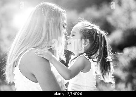 I bambini amano. Lifestyle ritratto mamma e figlia di buon umore all'esterno. Famiglia felice amorevole - madre e figlia. Foto Stock