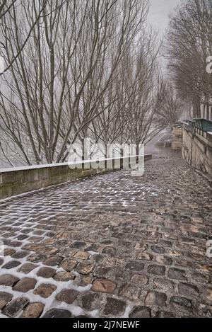 La riva destra del fiume Senna sotto la neve in discesa, visto guardando giù da Quai Francis Mitterrand. Foto Stock