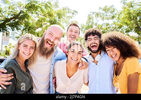 Gruppo allegro di amici in posa per una foto e divertirsi. Amicizia e concetto di comunità Foto Stock