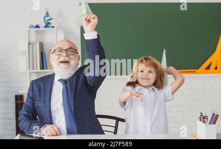 Nonno che aiuta a nipote con incarico scolastico. Sviluppare studenti attenti che stanno attivamente crescendo e conseguendo. Pedagoga e allievo vecchio Foto Stock