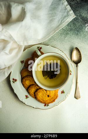 Dolci orecchie di maiale biscotti e tazza di tè Foto Stock