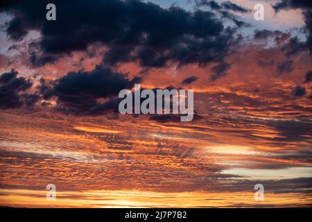 Un'alba dipinge le nuvole di ogni colore dell'arcobaleno in pianura Foto Stock