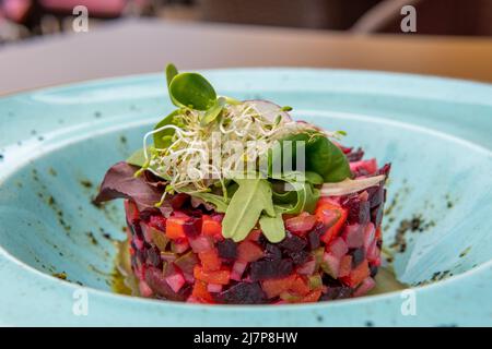 Vinaigrette a piastra blu decorate con micro green Foto Stock