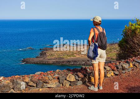 Donna che guarda il mare dalla cima del vulcano chiamato Monte Nero, Linosa. Sicilia. Italia Foto Stock