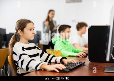 Teen studentessa imparando i principi fondamentali di programmazione in college di calcolatore Foto Stock