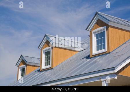 Finestre dormer e tetto in lamiera d'argento su replica di vecchia casa in stile cottage Canadiana 1800s. Foto Stock