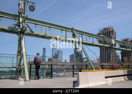 New York, Stati Uniti. 05th maggio 2022. Un visitatore sorge in un nuovo parco sul tetto di un ponte di atterraggio ristrutturato sul fiume Hudson. Lo spazio verde di circa 8.000 metri quadri chiamato 'Pier 57' offre, tra le altre cose, spazio sul prato, fiori, panchine e una vista panoramica di Manhattan e dello stato del New Jersey sull'altro lato del fiume Hudson. Credit: dpa/dpa/Alamy Live News Foto Stock