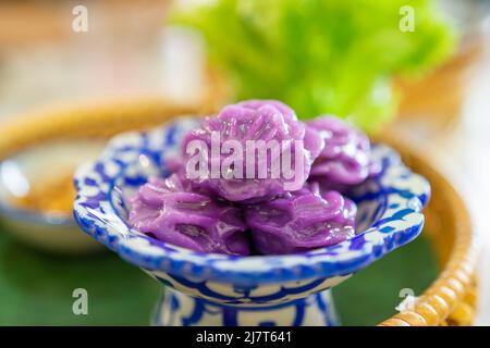 Il CHor Muang è un tradizionale dessert tailandese vintage a forma di fiori al vapore su un piatto antico nel piatto di vimini. Foto Stock