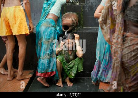 Una donna pilgim che prende un bagno in acqua Santa da una sorgente calda, che si ritiene abbia qualità curative, all'interno del complesso di tempio di Lakshmi Narayan in Rajgir, Bihar, India. Foto Stock