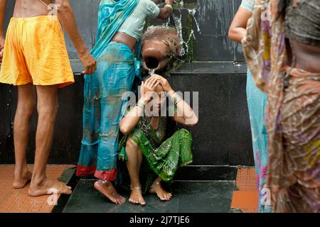 Una donna pilgim che prende un bagno in acqua Santa da una sorgente calda, che si ritiene abbia qualità curative, all'interno del complesso di tempio di Lakshmi Narayan in Rajgir, Bihar, India. Foto Stock