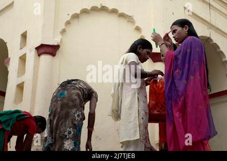 Una donna pellegrina ritoccando il suo trucco dopo aver preso un bagno in una sorgente calda, che si ritiene abbia qualità curative, situato all'interno del complesso di tempio di Lakshmi Narayan in Rajgir, Bihar, India. Foto Stock