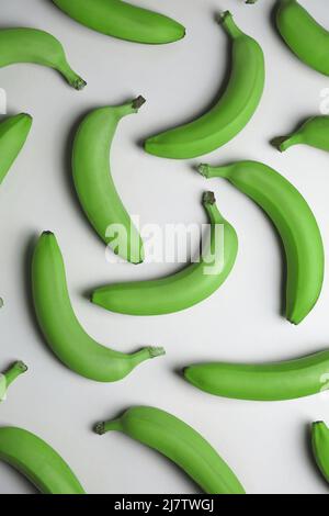 Banane verdi fresche su sfondo chiaro Foto Stock
