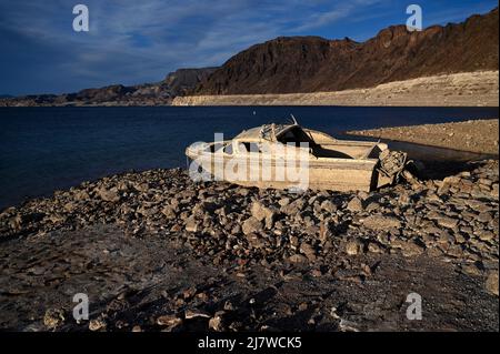 10 maggio 2022 - Lake Mead National Recreation Area, Nevada, Stati Uniti - Una barca precedentemente sommersa è visto poggiare su terra asciutta vicino a un ''anello della vasca'' di depositi minerali lasciati dai livelli più alti dell'acqua lungo il lago Mead colpito dalla siccità all'area di ricreazione nazionale del lago Mead, 10 maggio 2022, Vicino a Las Vegas, Nev. il Bureau degli Stati Uniti di Reclamation ha riferito che il lago Mead, il più grande serbatoio artificiale del Nord America, è sceso a circa 1.052 piedi sopra il livello del mare, il più basso è stato da allora essere riempito nel 1937 dopo la costruzione della diga di Hoover. Due serie di resti umani sono stati scoperti recentemente come Foto Stock