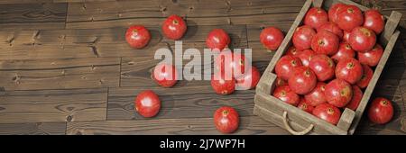 melograni, frutta succosa in una cassa di legno su striscione di legno Foto Stock