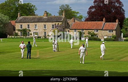 Partita di cricket in corso nel villaggio di Crakehall, North Yorkshire, Inghilterra Regno Unito Foto Stock