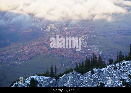 Scatto panoramico aereo della città di Zarnesti, con le nuvole sullo sfondo, catturato dai monti Piatra Craiului, in Romania Foto Stock