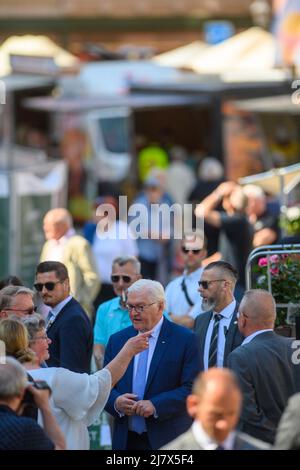 Quedlinburg, Germania. 11th maggio 2022. Il presidente tedesco Frank-Walter Steinmeier cammina attraverso il mercato settimanale e parla con un passerby. La seconda giornata è dedicata allo scambio e alla discussione. Persone della società civile e delle imprese, per esempio, sono invitati alla 'polemica Coffee Table' nel pomeriggio. I temi da discutere includono le questioni locali, la pandemia di Corona e le conseguenze della guerra in Ucraina. Successivamente, visiterà la Galleria Lyonel Feininger. Credit: Klaus-Dietmar Gabbert/dpa/Alamy Live News Foto Stock