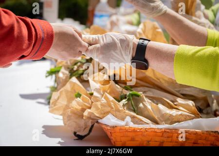 Uomo che paga per l'acquisto sul mercato del festival all'aglio arrosto a Arnodo, la Rioja, Spagna Foto Stock