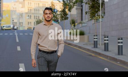 Successo felice bel uomo d'affari ispanico sorridente ragazzo arabo capo lavoratore arabo maschio manager uomo turistico in abiti formali a piedi in strada Foto Stock