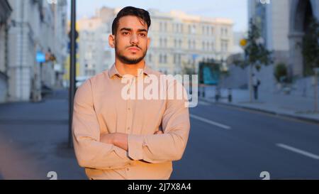 Pensive profondo nei pensieri che pensano la pianificazione futura sognando uomo d'affari del tipo sognante ported il boss convenzionale che si levano in piedi in città con le armi incrociate che posano Foto Stock