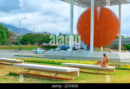 Caracas, Venezuela - 1 maggio 2022. Donna apprezzare l'arte scultura cinetica Esfera Caracas, di Jesus Soto, sulla Francisco Fajardo Highway. Foto Stock