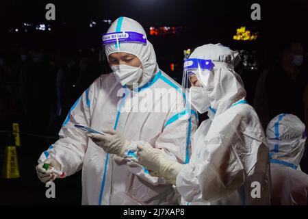 Changzhou, Cina. 10th maggio 2022. Il personale medico che indossa gli attrezzi di protezione è visto smistare fuori i campioni prelevati del tampone della bocca dei residenti mentre attendono di inviarli al laboratorio per il test dell'acido nucleico del covid-19. La Cina continentale lunedì ha segnalato 349 casi confermati COVID-19 locali, di cui 234 erano a Shanghai, ha detto martedì la Commissione Nazionale della Sanità. Oltre a Shanghai, altre sette regioni a livello provinciale sul continente hanno visto nuovi casi COVID-19 trasmessi localmente, di cui 61 a Pechino e 25 ad Henan. Credit: SOPA Images Limited/Alamy Live News Foto Stock