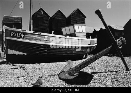 Barche da pesca in camicia e negozi di rete sulla Stade a Hastings, East Sussex, South East England Foto Stock