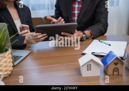 Persone aziendali che hanno una riunione in ufficio con notebook e modelli architettonici. Foto Stock