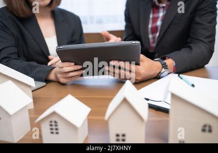 Persone aziendali che hanno una riunione in ufficio con notebook e modelli architettonici. Foto Stock