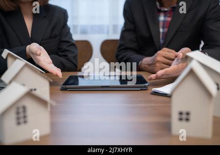 Persone aziendali che hanno una riunione in ufficio con notebook e modelli architettonici. Foto Stock