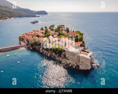 Aerofotografia. Vista dal drone volante. Vista panoramica dell'isola di Sveti Stefan a Budva in una splendida giornata estiva, Montenegro. Vista dall'alto. Bellissima Foto Stock