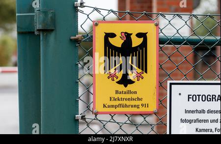 Bramstedtlund, Germania. 11th maggio 2022. Un cartello con la scritta "Battaglione guerra elettronica 911" è appeso su una recinzione all'ingresso della posizione di ricognizione di Bundeswehr a Bramstedtlund. Il ministro della Difesa Lambrecht ha visitato questo stabilimento il 13 aprile 2022, che cerca, rileva e valuta le emissioni nello spettro elettromagnetico. Credit: Markus Scholz/dpa/Alamy Live News Foto Stock