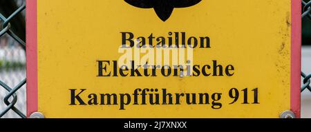 Bramstedtlund, Germania. 11th maggio 2022. Un cartello con la scritta "Battaglione guerra elettronica 911" è appeso su una recinzione all'ingresso della posizione di ricognizione di Bundeswehr a Bramstedtlund. Il ministro della Difesa Lambrecht ha visitato questo stabilimento il 13 aprile 2022, che cerca, rileva e valuta le emissioni nello spettro elettromagnetico. Credit: Markus Scholz/dpa/Alamy Live News Foto Stock