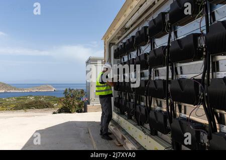 Atene, Grecia. 9th maggio 2022. Un dipendente lavora alle batterie del sistema di accumulo di energia sull'isola di Tilos, Grecia, 9 maggio 2022. Tilos, una piccola isola nel sud-est dell'Egeo con oltre 500 abitanti, è la prima isola della Grecia ad affidarsi interamente all'energia rinnovabile per soddisfare il suo fabbisogno energetico. Dopo essere stata autosufficiente in energia attraverso l'energia eolica e solare, l'isola, con circa il 80 per cento dei suoi rifiuti ora riciclati, mira anche a diventare un'isola 'zero rifiuti'. Credit: Marios Lolos/Xinhua/Alamy Live News Foto Stock