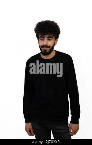 Giovane maschio ricci con capelli ricci in maglione nero si distingue per la sua spensieratezza. Isolato su sfondo bianco Foto Stock