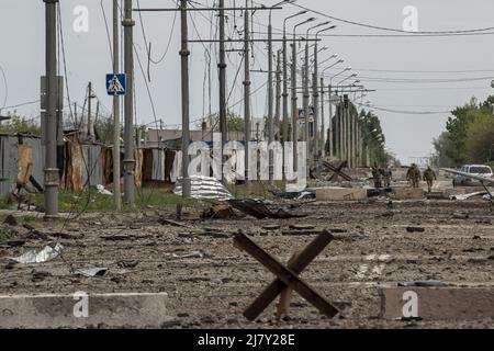 Kharkiv, Ucraina. 11th maggio 2022. I soldati ucraini percorrono una strada disseminata di detriti provenienti dall'abbattimento russo nella parte settentrionale di Kharkiv, Ucraina, mercoledì 11 maggio 2022. Martedì gli Stati Uniti e i suoi alleati europei hanno accusato la Russia di un attacco informatico lanciato un'ora prima dell'invasione di febbraio del Cremlino dell'Ucraina che ha preso di mira una società di comunicazione statunitense che opera a Kiev, causando danni in tutto il continente. Foto di Ken Cedeno/UPI Credit: UPI/Alamy Live News Foto Stock