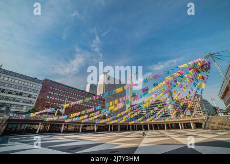 Lone persona in piazza vuota della città piena di piccole bandiere colorate appese da solo nel cielo è vuoto a causa del convivio 19, covid19 o epidemia pandemica Foto Stock