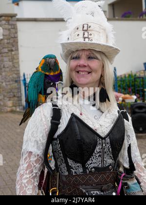 Donna pirata con un pappagallo al Brixham Pirate Festival 2022, Devon, Regno Unito Foto Stock