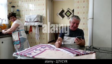 Felice uomo anziano che celebra le notizie sul cellulare. Senior sceglie lo smartphone con gioia Foto Stock