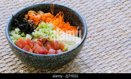 Cibo sano, concetto di cibo pulito. Pesce, verdure, alghe marine in ciotola di poke Foto Stock