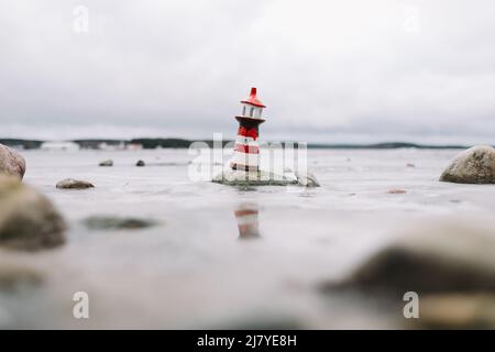 Mare d'inverno ghiacciato con faro decorativo. Stile di vita nautico. Inverno, Mare, Viaggi, avventura, vacanze e vacanza concetto. Foto Stock